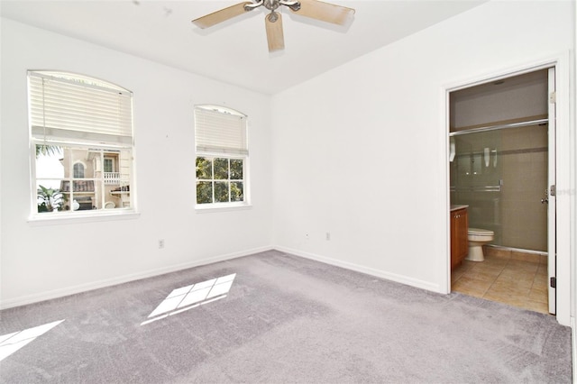 8766 The Esplanade Unit 23, Orlando, FL 32836 - unfurnished bedroom featuring tile patterned flooring, baseboards, carpet floors, a ceiling fan, and ensuite bathroom