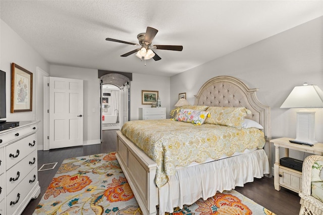 bedroom featuring arched walkways, a textured ceiling, visible vents, a ceiling fan, and dark wood finished floors