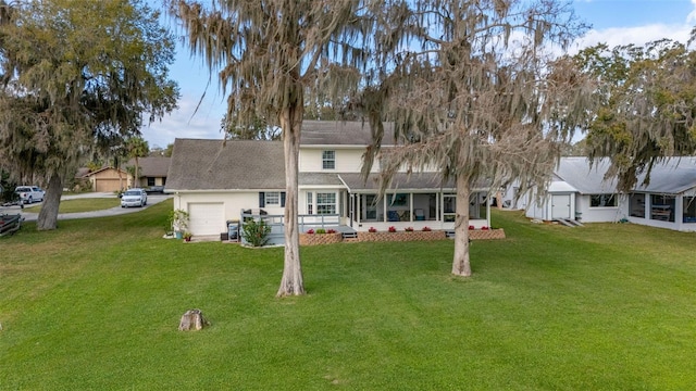 rear view of house featuring a yard, driveway, and an attached garage