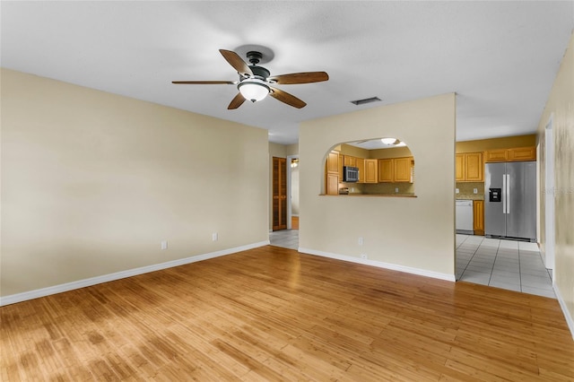 unfurnished living room featuring ceiling fan and light wood-type flooring