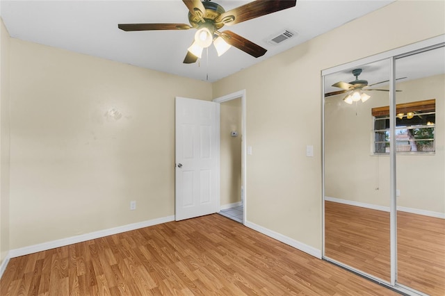 unfurnished bedroom with hardwood / wood-style floors, a closet, and ceiling fan