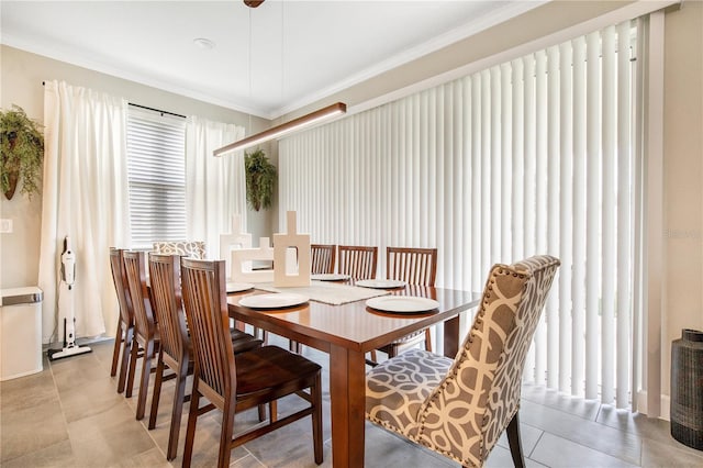 dining area featuring light tile patterned floors and crown molding