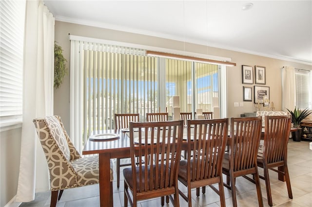 dining space featuring light tile patterned floors and crown molding