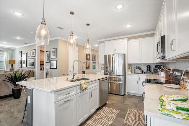 kitchen featuring an island with sink, sink, white cabinets, and stainless steel appliances