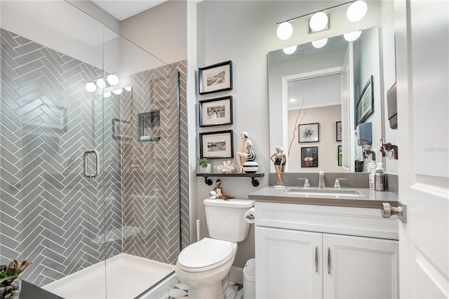 bathroom featuring vanity, a shower with shower door, and toilet