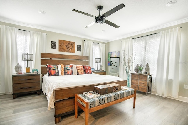 bedroom featuring light hardwood / wood-style flooring, ceiling fan, and ornamental molding