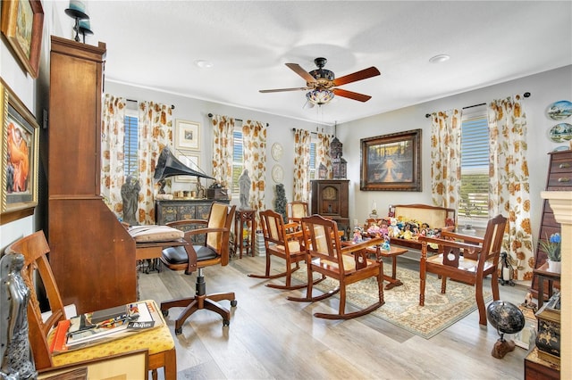 living area featuring light wood-type flooring and ceiling fan