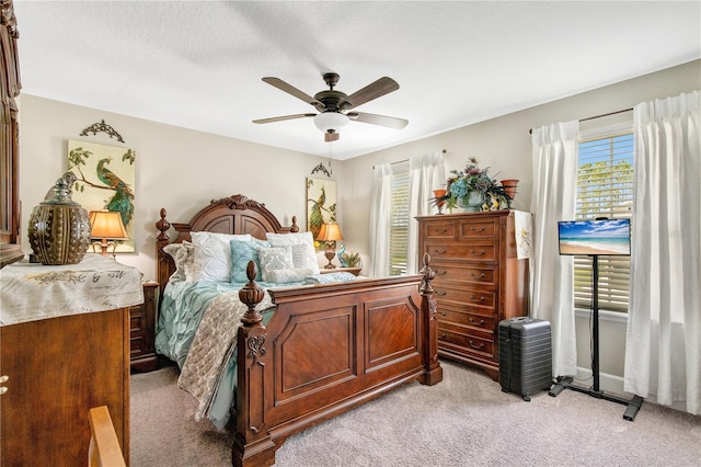 bedroom featuring a textured ceiling, ceiling fan, and light colored carpet