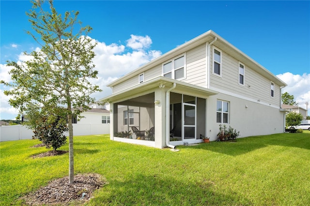 back of house featuring a yard and a sunroom