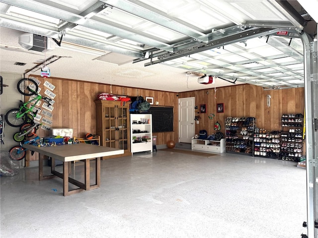 garage with wooden walls and a garage door opener