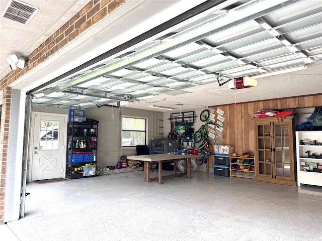 garage with a garage door opener and a workshop area