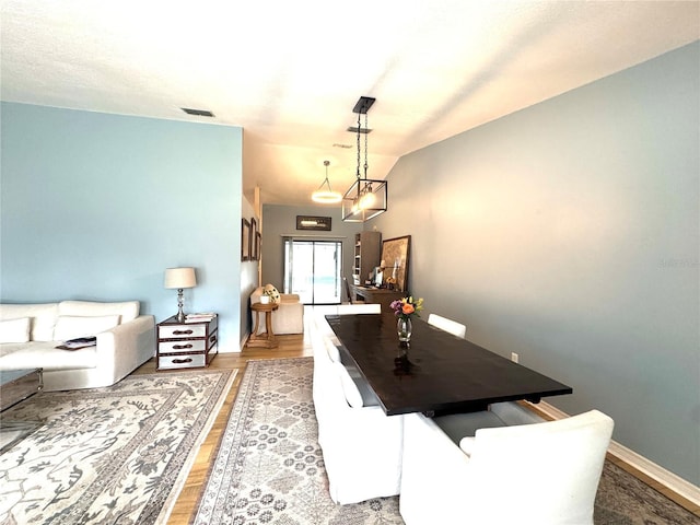 dining area with light hardwood / wood-style floors and lofted ceiling