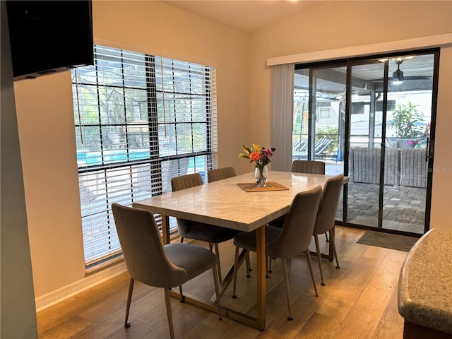 dining space featuring lofted ceiling and light hardwood / wood-style floors