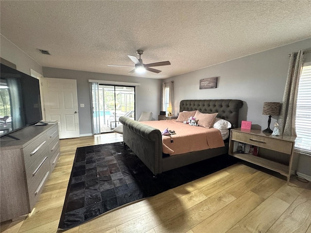 bedroom with light wood-type flooring, access to outside, a textured ceiling, and ceiling fan