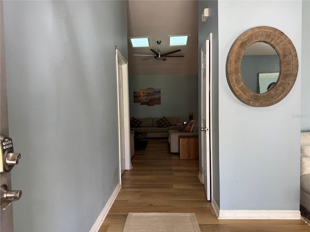 hall featuring a skylight and light hardwood / wood-style floors