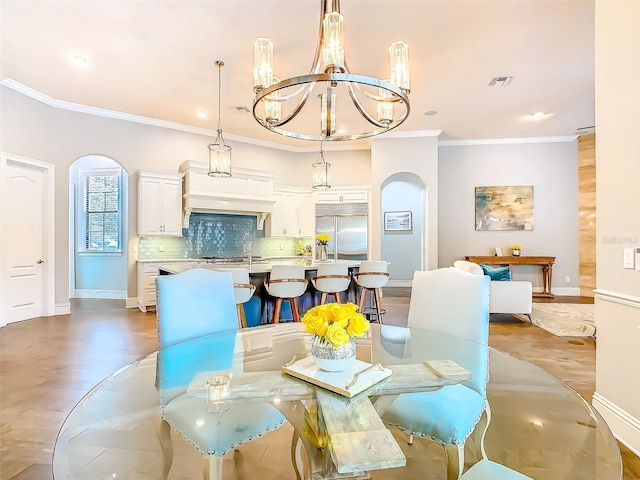 dining area featuring crown molding, arched walkways, a notable chandelier, and visible vents