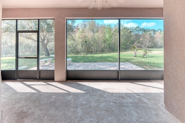 unfurnished sunroom featuring ceiling fan