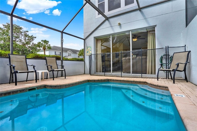 view of swimming pool with glass enclosure, a fenced in pool, and a patio