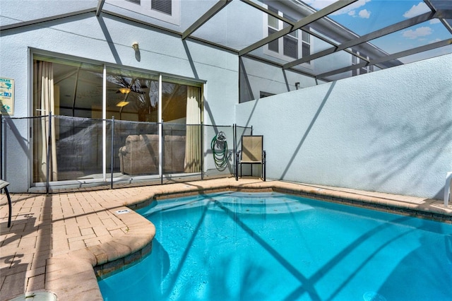 view of swimming pool with glass enclosure, a patio area, and a fenced in pool