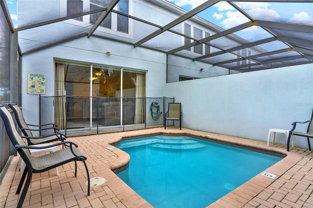 pool featuring glass enclosure and a patio