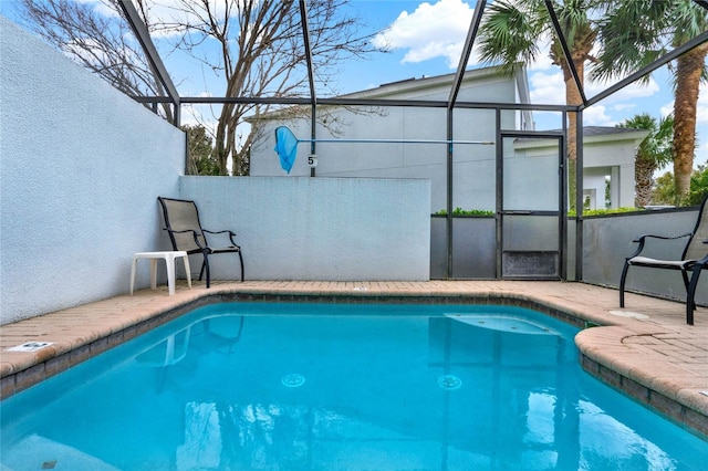 outdoor pool with a lanai and a patio area