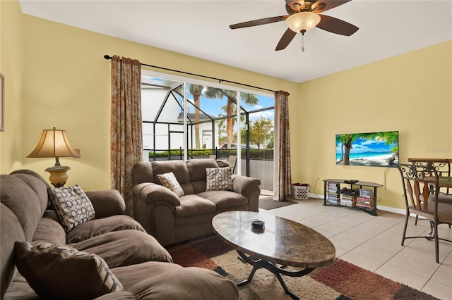 living room with a sunroom, ceiling fan, baseboards, and light tile patterned floors