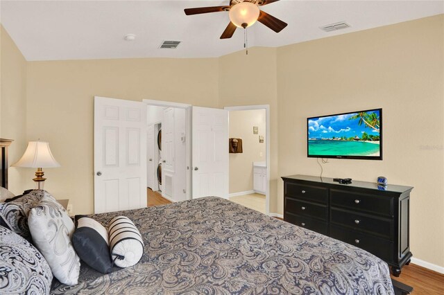 bedroom with baseboards, visible vents, vaulted ceiling, and wood finished floors