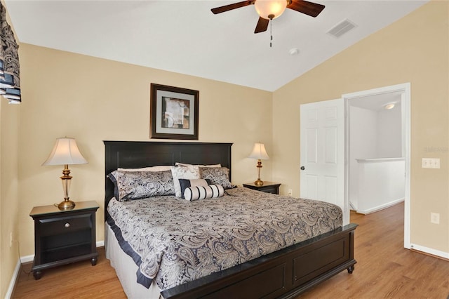 bedroom with baseboards, visible vents, a ceiling fan, lofted ceiling, and light wood-style floors