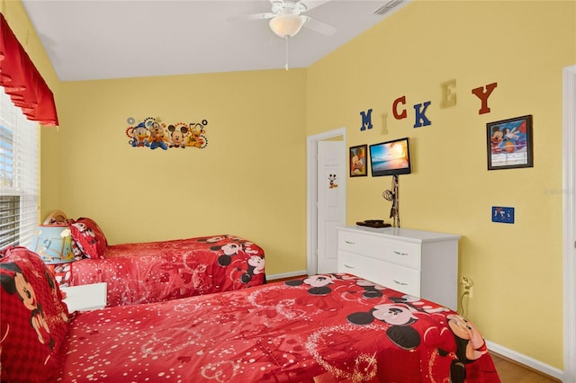 bedroom with baseboards, visible vents, vaulted ceiling, and a ceiling fan