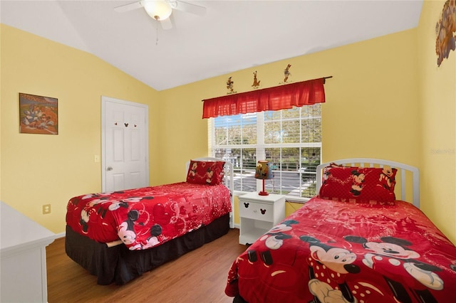 bedroom with ceiling fan, vaulted ceiling, and wood finished floors