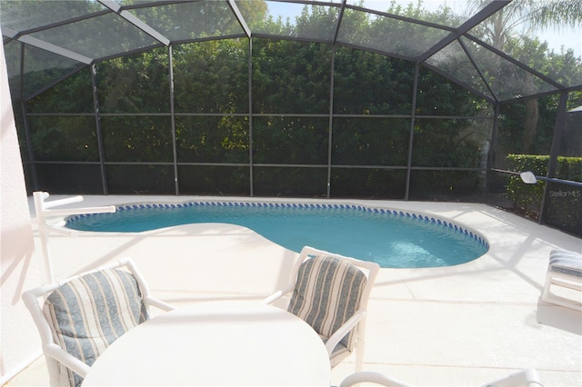 pool with glass enclosure and a patio