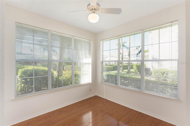 unfurnished sunroom with ceiling fan