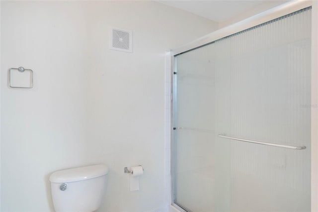 bathroom with toilet and a shower with shower door