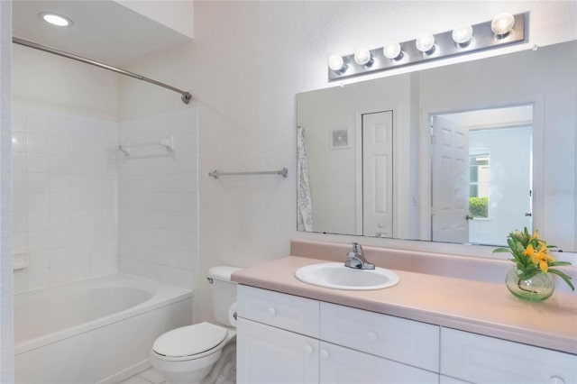 full bathroom featuring tiled shower / bath combo, toilet, and vanity