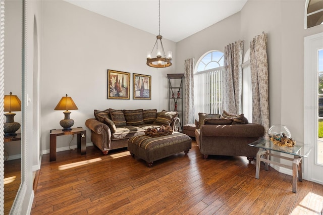 living room featuring a high ceiling, dark hardwood / wood-style floors, and a notable chandelier