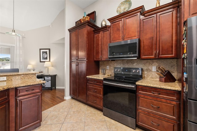 kitchen featuring backsplash, hanging light fixtures, light stone countertops, and stainless steel appliances