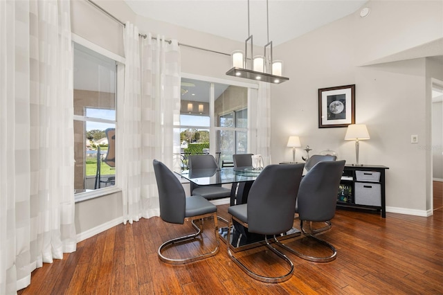 dining space with dark hardwood / wood-style floors and a notable chandelier