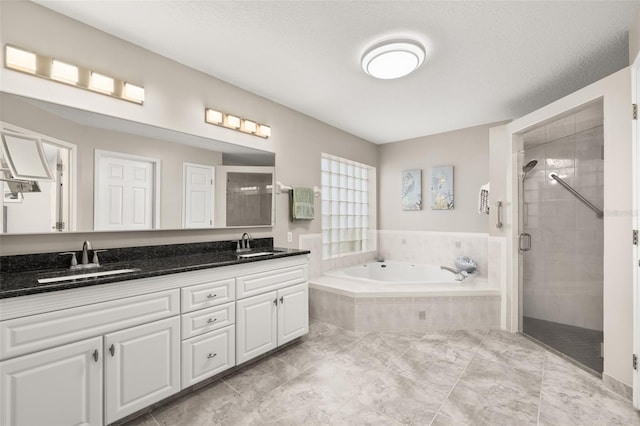 bathroom featuring a textured ceiling, vanity, and independent shower and bath