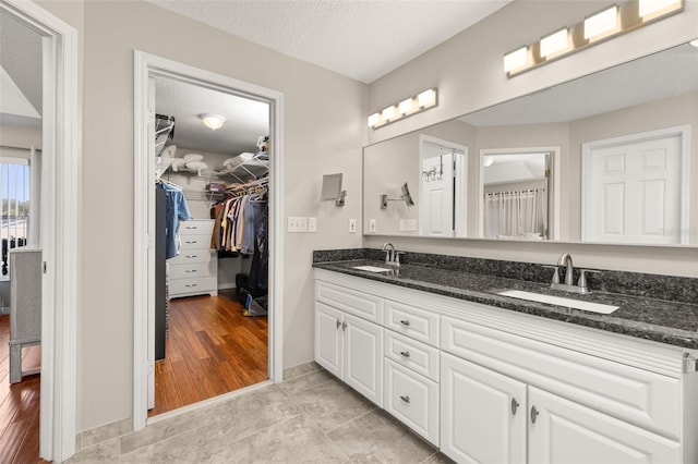 bathroom featuring a textured ceiling, wood-type flooring, and vanity