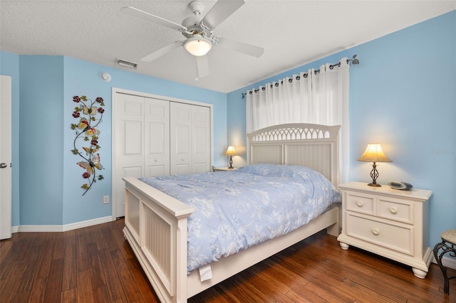 bedroom featuring ceiling fan, dark hardwood / wood-style floors, a textured ceiling, and a closet