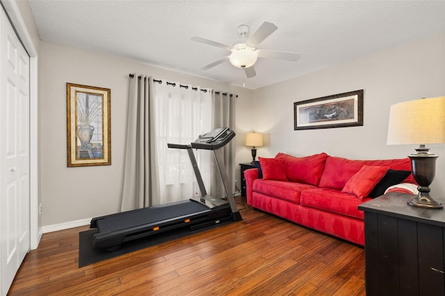 workout room featuring a textured ceiling, dark hardwood / wood-style floors, and ceiling fan