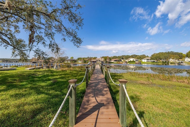 dock area with a yard and a water view