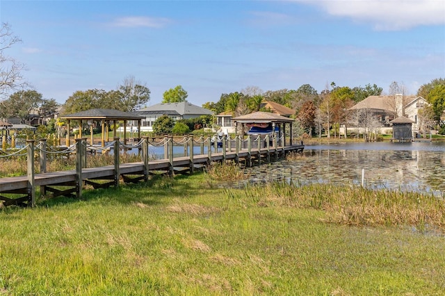 view of dock with a lawn, a water view, and a gazebo