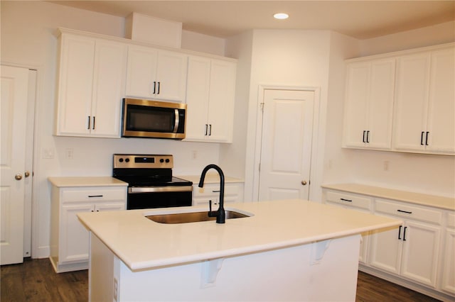 452 Diamond Dove Cv, Winter Springs, FL 32708 - kitchen with appliances with stainless steel finishes, sink, white cabinets, dark hardwood / wood-style flooring, and a center island with sink