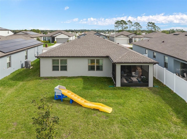 rear view of house with a shingled roof, a residential view, a playground, and fence