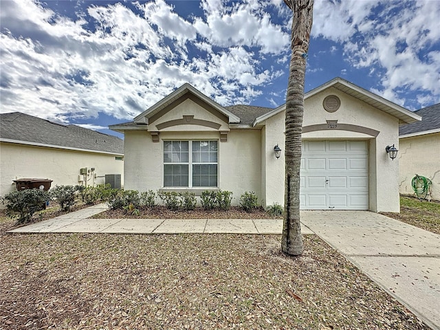 ranch-style home featuring a garage, concrete driveway, central AC unit, and stucco siding