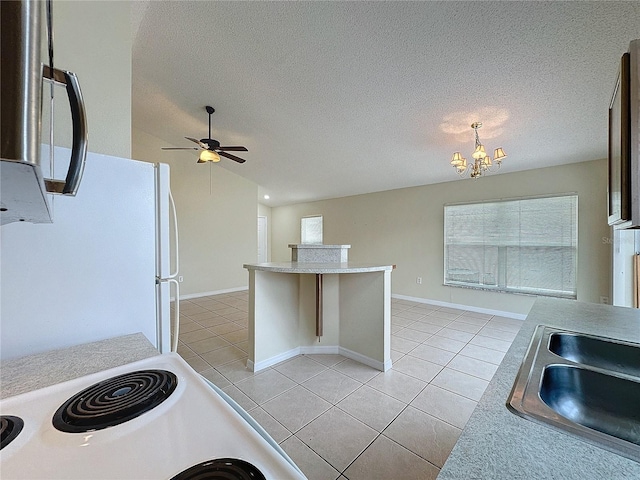 kitchen with light tile patterned floors, a textured ceiling, lofted ceiling, white appliances, and light countertops