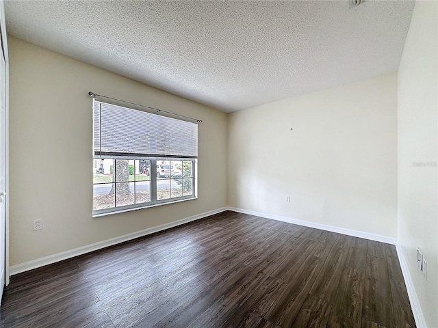 unfurnished room featuring baseboards, dark wood finished floors, and a textured ceiling