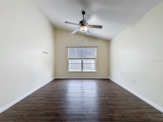 empty room with dark wood-style floors, lofted ceiling, a textured ceiling, and baseboards