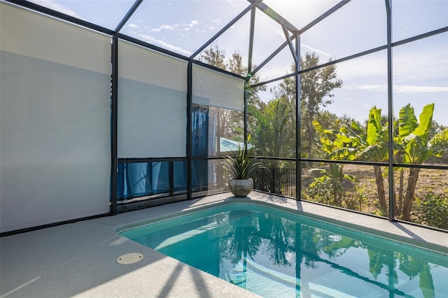 pool featuring glass enclosure and a patio